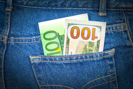 Blue jeans pocket with one hundred euro and one hundred american dollar
