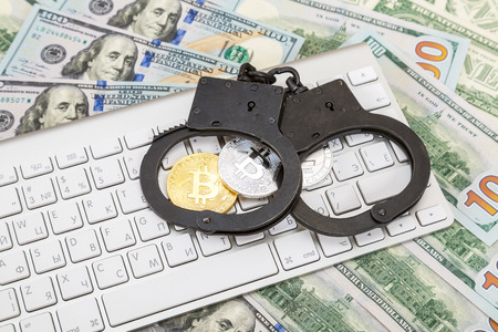Moscow, Russia - November 5, 2017: Steel handcuffs and coins of cryptocurrency lying over computer keyboardのeditorial素材