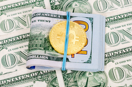 Gold bitcoin lying over american dollar bills. Business conceptの写真素材