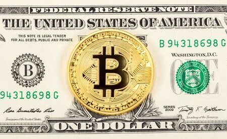 Cryptocurrency of the Bitcoin lying on the american dollar banknote. Business concept of new virtual moneyの写真素材