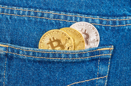 Coins of Cryptocurrency sticking out of the back jeans pocket. Business concept of digital moneyの写真素材