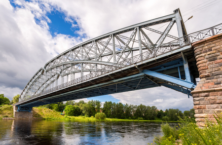 First in Russia steel arch bridge on river Msta in sunny summer day. Was built in 1905. Borovichi, Russiaのeditorial素材