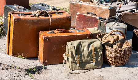 Vintage travel luggage with old suitcases and basket in sunny dayの写真素材