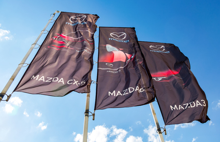 Samara, Russia - May 19, 2018: Mazda dealership flags over blue sky. Mazda Motor Corporation is a Japanese automakerのeditorial素材