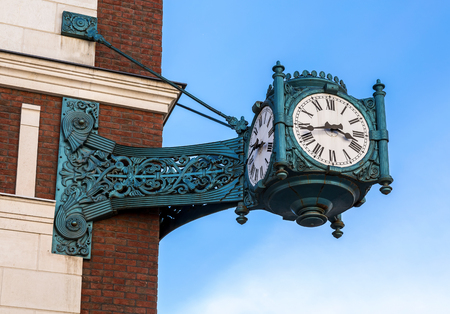 Vintage street clock hanging on a corner of brick building in Samara, Russiaの写真素材