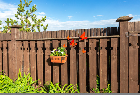 Flower pot with decorative flowers hanging on the wooden fence in villageの写真素材