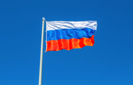 Flag of Russia waving in the wind against the blue sky