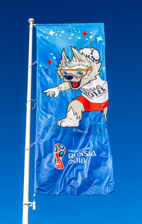Samara, Russia - June 17, 2018: Flag with official mascot of 2018 FIFA World Cup Zabivaka against the blue skyのeditorial素材