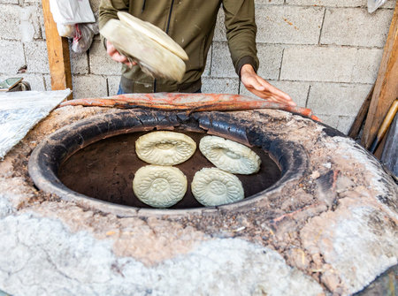 Traditional Uzbek flatbread baking in the tandyr oven