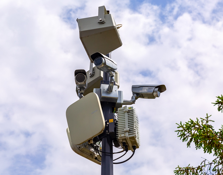 Samara, Russia - June 12, 2018: Surveillance CCTV cameras mounted on post against the cloudy skyのeditorial素材