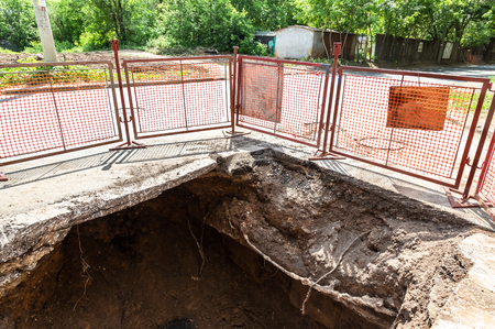 Repair  works on heating pipes at a depth of excavated trenchの写真素材