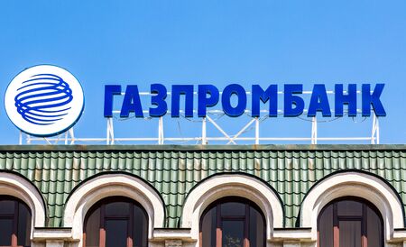 Samara, Russia - June 12, 2019: Sign with the logo of the Russian Gazprombank against the blue sky. Text in russian: Gazprombankのeditorial素材