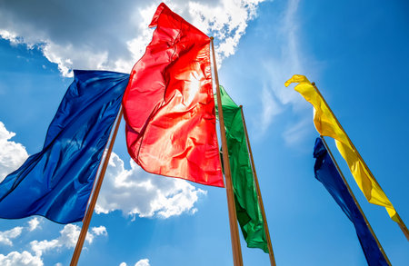Colorful flags in the wind against the blue sky background