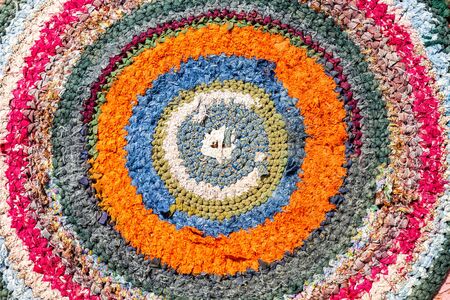 Old handicraft rug made from strips of cloth as background. Texture of a homespun doormat from different fabricsの写真素材