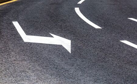 Traffic sign white arrow on asphalt road close upの写真素材