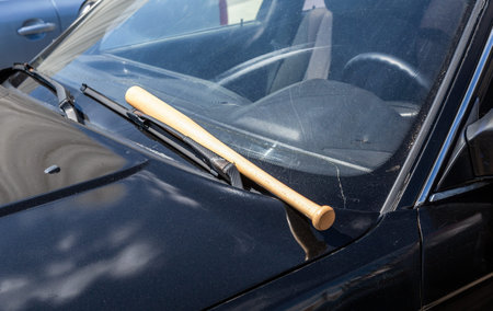 Wooden baseball bat lies on the black carの写真素材