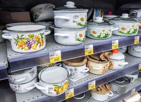 Samara, Russia - September 26, 2019: Different metal enamelware, cooking pots containers utensils for sale on store shelfのeditorial素材