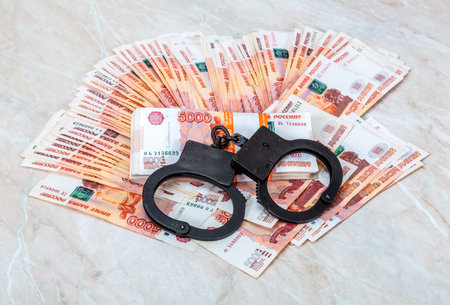 Black steel handcuffs lying on the heap of Russian banknotes