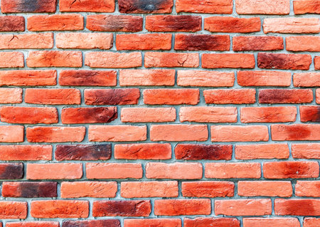 Old weathered red brick wall as background. Bricks masonry with seams