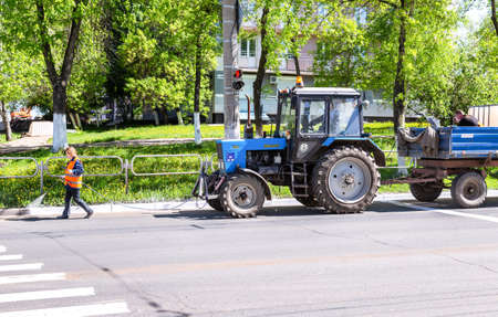 Samara, Russia - May 14, 2020: Road works on painting curbstone fenced on the asphalt roadのeditorial素材