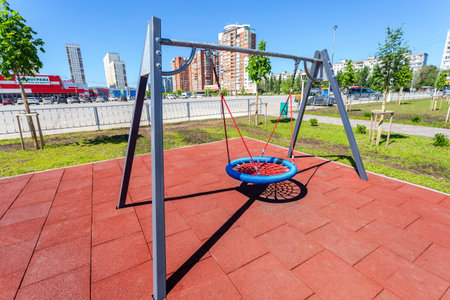 Samara, Russia - May 29, 2020: Children's playground for kids in new district with swing for play and rest. Recreation site with swing in cityのeditorial素材