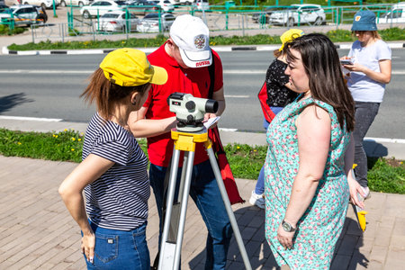 Samara, Russia - June 12, 2019: Students conduct classes on geodetic works with geodetic optical...