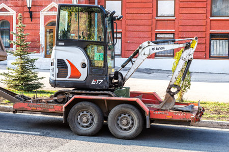 Samara, Russia - October 29, 2020: Transportation of small backhoe on a cargo platform