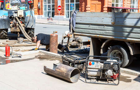 Samara, Russia - May 6, 2021: Workers carry out repair work on the city sewerのeditorial素材