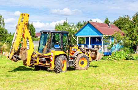 Moscow, Russia - July 30, 2021: JCB wheeled tractor excavating at the village in summerのeditorial素材