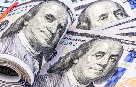 Folded american dollars banknotes wrapped by rubber band over dollars banknotes. business concept