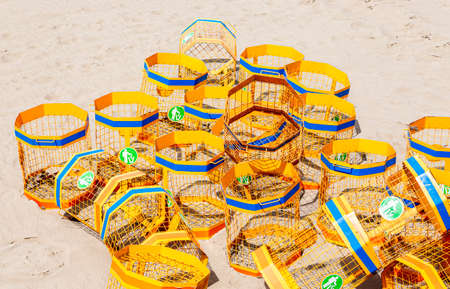 Metal containers for waste at the sand beach in summerの写真素材