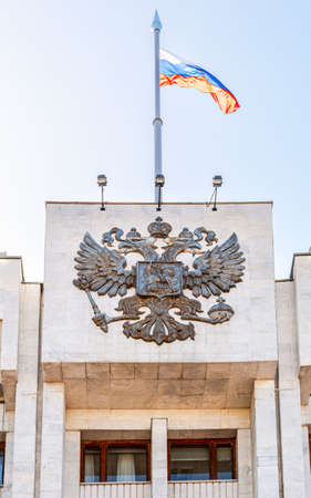 Russian coat of arms and the state flag on the administrative buildingの写真素材