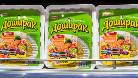 Samara, Russia - April 16, 2022: Chinese noodles Doshirak in a plastic boxes on the shelf in a superstore. Instant noodles. selective focusのeditorial素材