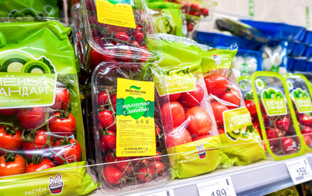 Samara, Russia - April 16, 2022: Fresh natural tomatoes in plastic bags are sold on a shelf in a storeのeditorial素材