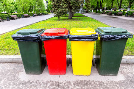 Multicolored plastic containers for separate collection of waste in the city park. Separate garbage containers according to waste typeの写真素材