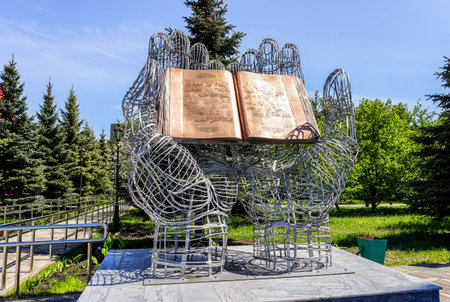 Samara, Russia - May 8, 2022: Sculptural composition Quran in open palms on the territory of the...