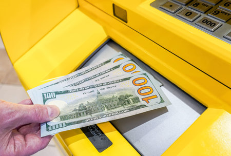 Depositing and withdrawing cash american dollar banknotes from cash dispenser. economic and...