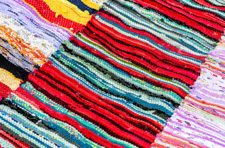 Creative background from handmade doormats. Texture of a homespun rug from different fabricsの写真素材