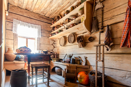 Veliky Novgorod, Russia - August 26, 2022: Interior of old traditional rural wooden house in russian village. Wooden shelves with old ceramic tableware. Museum of wooden architecture Vitoslavlitsyのeditorial素材