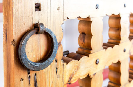 Massive wooden gate with metal forges knob close up