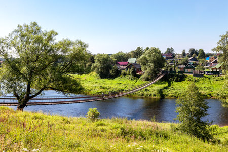 Suspension bridge across the Msta river in summer day next the Borovichi, Russiaの写真素材