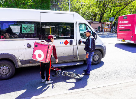 Samara, Russia - May 7, 2023: Car accident on a city street with a cyclist from a delivery service. Minivan ran over a cyclist from a delivery serviceのeditorial素材