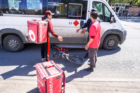 Samara, Russia - May 7, 2023: Car accident on a city street with a cyclist from a delivery service....