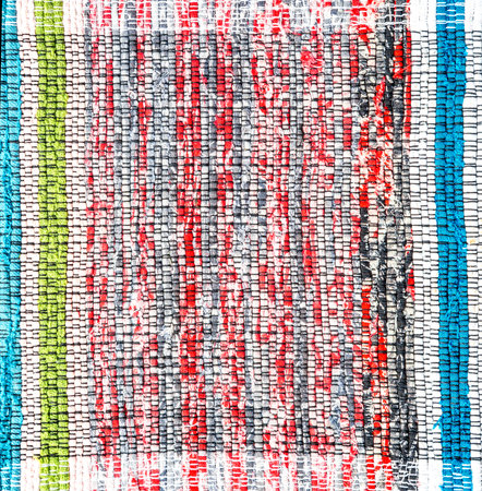 Old handmade homespun doormat from strips of cloth. Texture of a homemade rug from different fabricsの写真素材