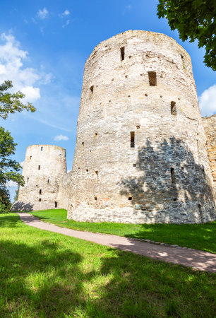 Stone tower of the ancient Izborsk fortress against a blue sky in summer. Izborsk, Pskov region, Russia. Medieval castle on the 14th centuryの写真素材