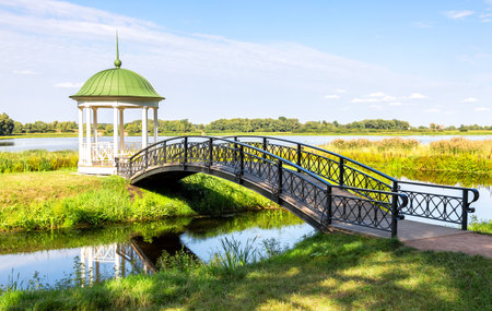 Gazebo and small arched bridge outdoors on a sunny summer dayの写真素材