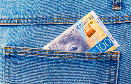 Swedish crown banknote sticking out of the back pocket of pocket