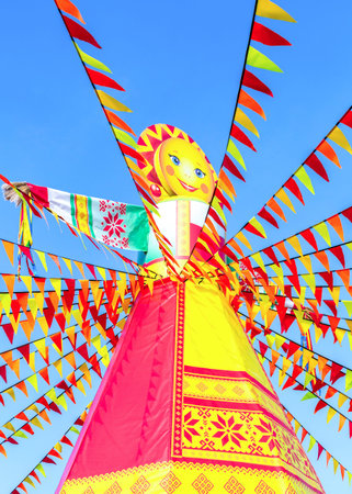 Samara, Russia - March 2, 2025:: Shrovetide in Russia. Big doll for the burning on the blue sky backgroundの写真素材