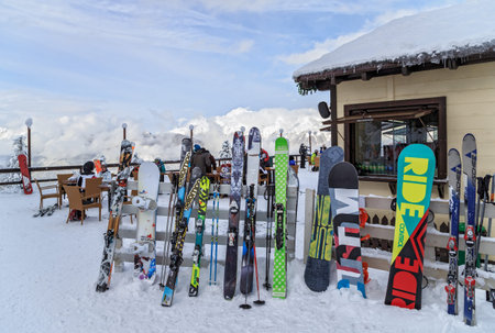 Sochi, Russia - January 9, 2015: Ski and snowboard equipment is resting against a winter cafe fence