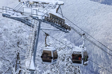 Sochi, Russia - January 9, 2015: Ski slopes and cableway gondola lifts in Krasnaya Polyana winter mountain resort can be hosting ski and snowboard riders right until June. Cabins close-up viewのeditorial素材